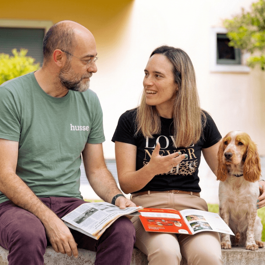 Couple filling in the Husse feeding questionnaire outdoors with their dog beside them