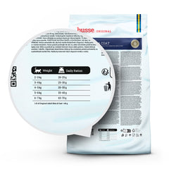 Feeding guide table for your cat, magnified on the back of a white husse Adult Skin & Coat bag.
