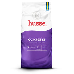 Ração seca Husse Complete para cães de porte grande em saco branco e roxo, que apoia a mobilidade e as articulações.