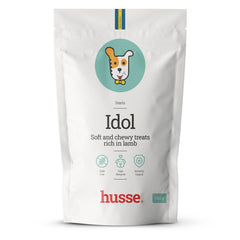 Embalagem branca de 100 g de snacks macios Husse Idol sem cereais ricos em borrego com ilustração de cão.