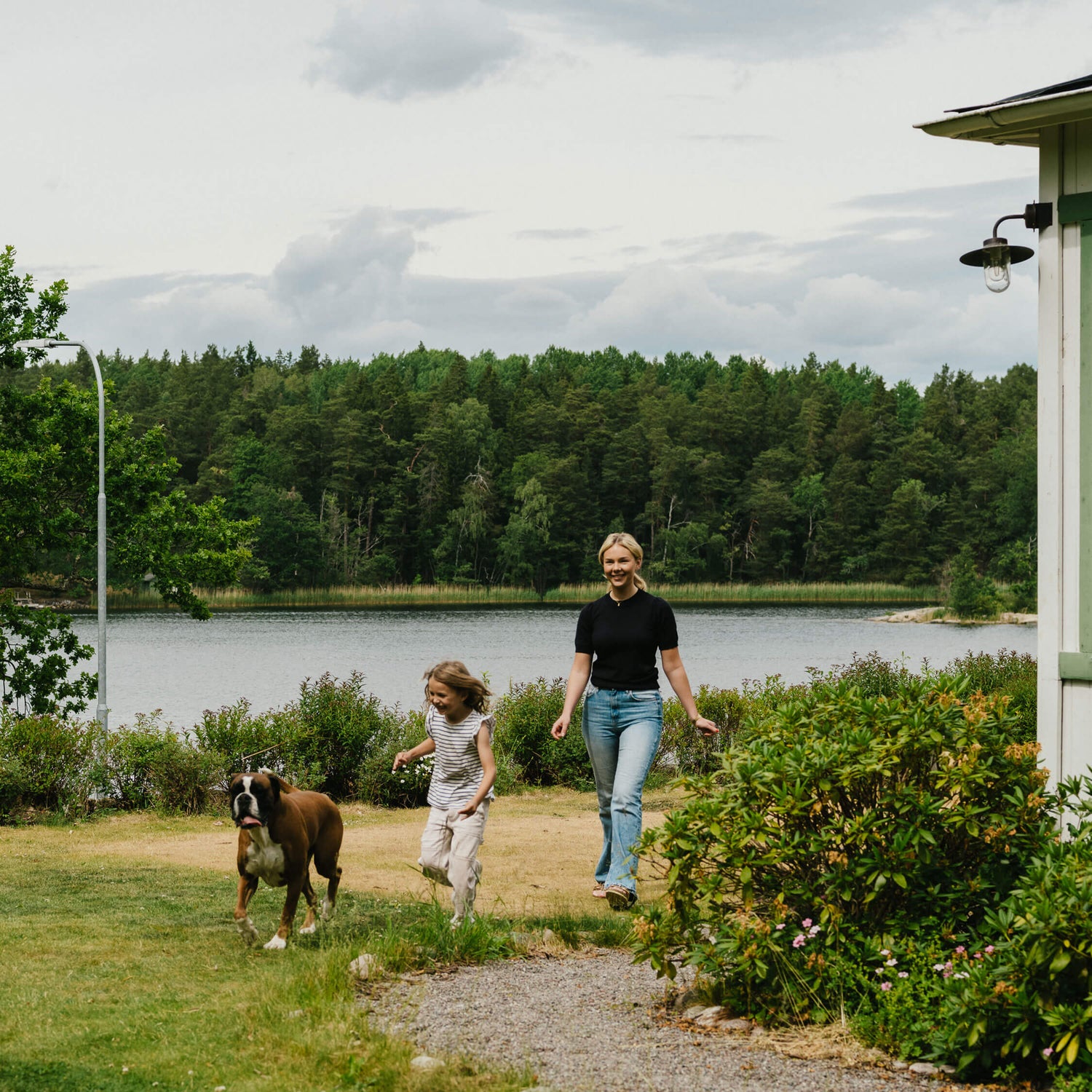 Family walking their dog beside a lake in the Swedish countryside