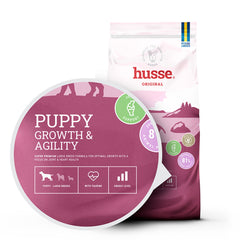 Saco de ração Husse Puppy Growth & Agility em branco e roxo para suporte articular de cachorros de raça grande.