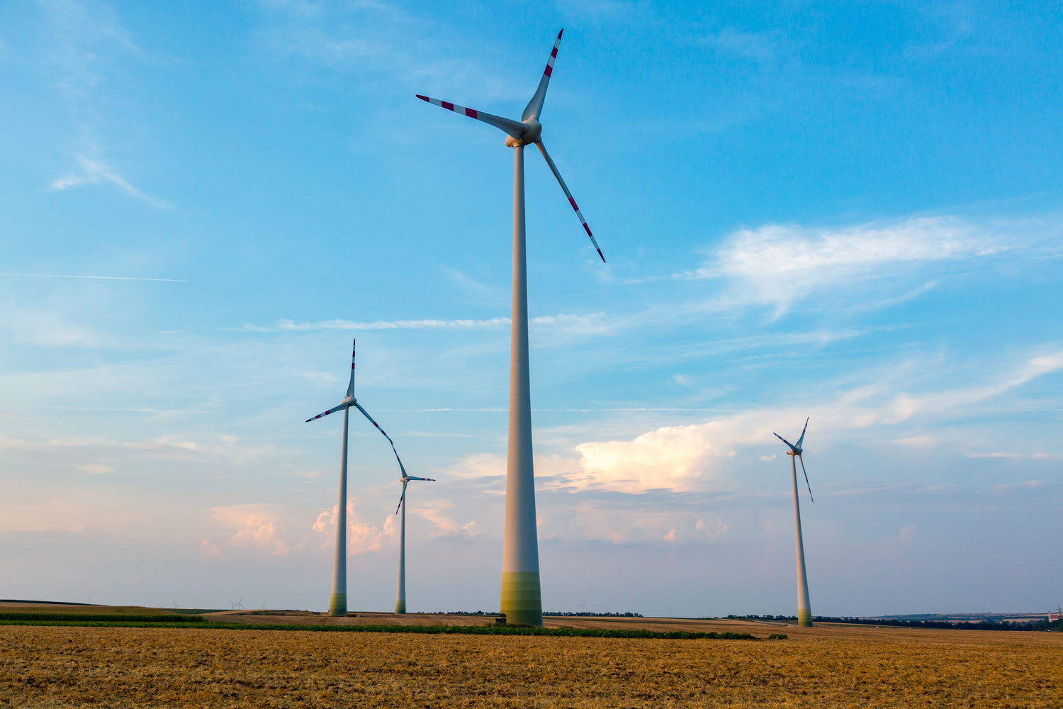 Row of wind turbines in a field, generating the power for Husse production
